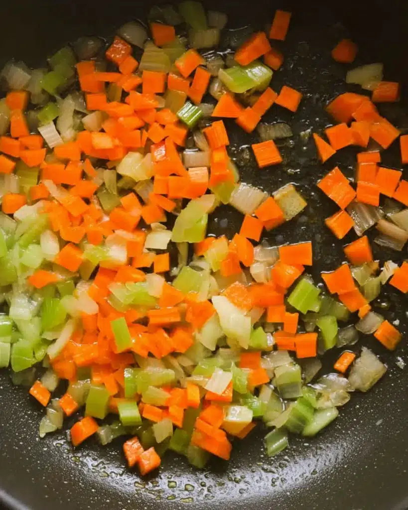 Diced carrots, celery, and onions sautéing in olive oil for white bean soup