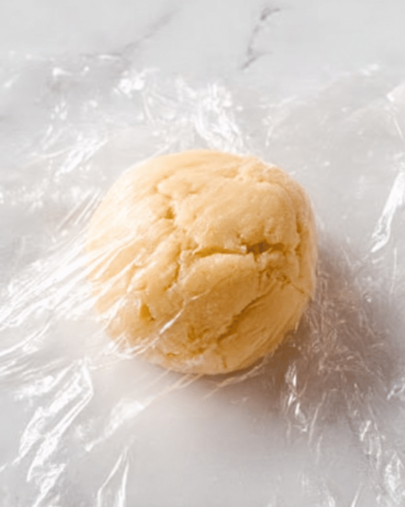 Thumbprint Cookies – A Classic Christmas Cookie Favorite 5 Ball of thumbprint cookie dough wrapped for chilling