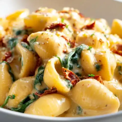 Tuscan Mac and Cheese (Thanksgiving Recipe) 8 Creamy Tuscan mac and cheese with sun-dried tomatoes and spinach in a white bowl