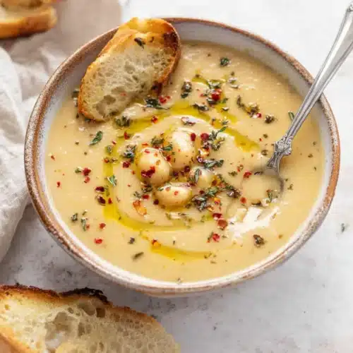 Vegan Garlic Chickpea Soup 5 Creamy vegan garlic chickpea soup with olive oil and herbs in a rustic bowl
