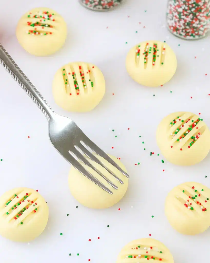 Whipped Shortbread Cookies (Melt-in-Your-Mouth Christmas Classic) 5 Unbaked whipped shortbread cookies pressed with fork and sprinkles