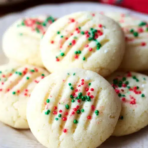 Whipped Shortbread Cookies (Melt-in-Your-Mouth Christmas Classic) 7 Whipped shortbread cookies with Christmas sprinkles on white plate