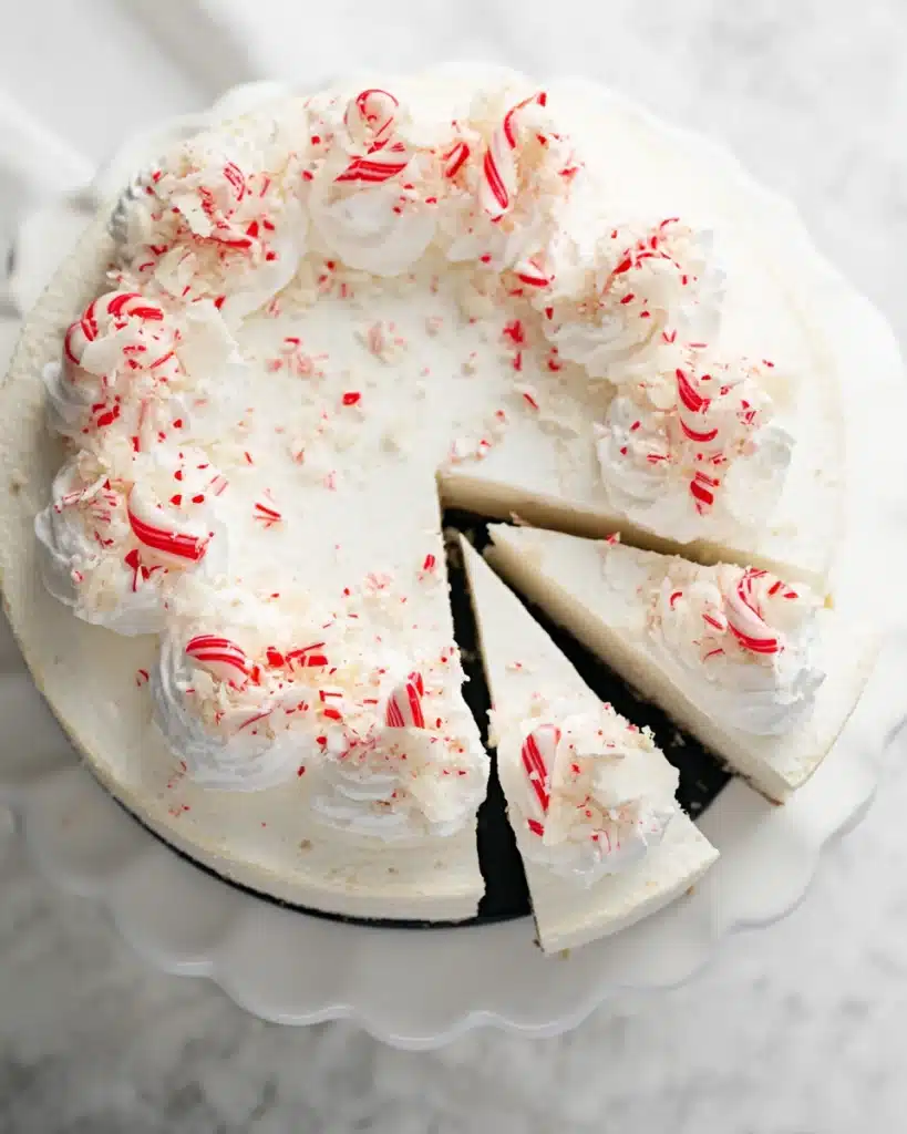 White Chocolate Peppermint Cheesecake 2 Overhead view of sliced white chocolate peppermint cheesecake with candy toppings
