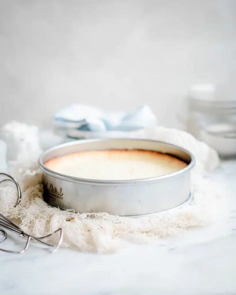 White Chocolate Peppermint Cheesecake 3 White chocolate peppermint cheesecake cooling in a springform pan on a white mat
