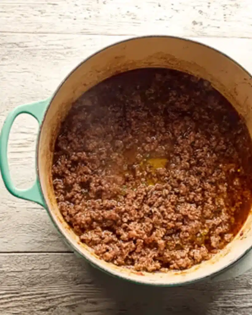 Creamy Tomato Beef Pasta (One Pot Dinner Recipe) 3 browning ground beef in mint green pot for creamy tomato beef pasta
