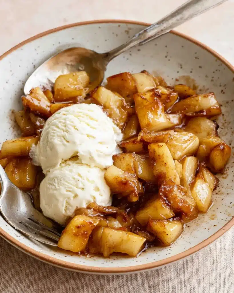 Warm air fryer apples with vanilla ice cream on a rustic plate