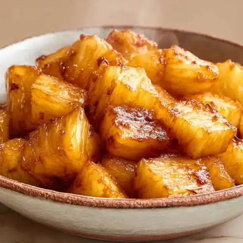 AIR FRYER PINEAPPLE (CARAMELIZED AND SWEET IN MINUTES) 5 Caramelized air fryer pineapple chunks in a rustic bowl