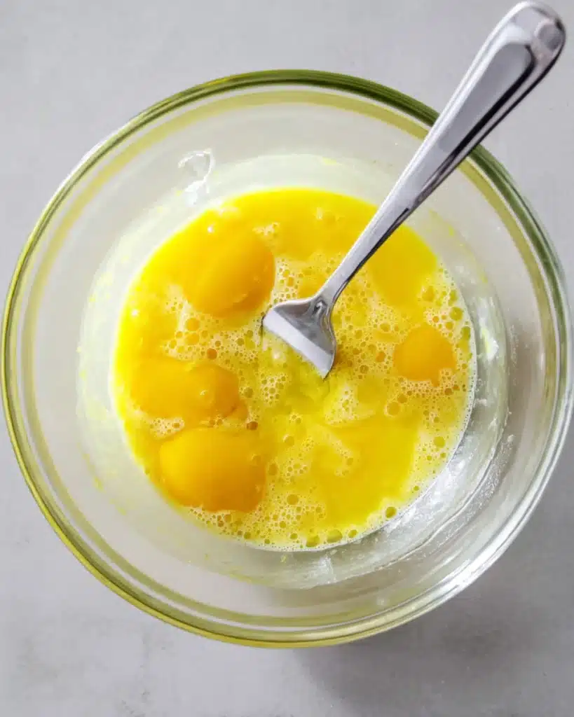 Beaten eggs in a glass bowl for air fryer zucchini fries coating