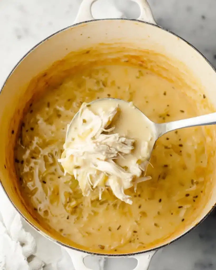 Avgolemono Soup (Greek Lemon Chicken & Rice Soup) 5 Creamy Avgolemono Soup with shredded chicken in white pot