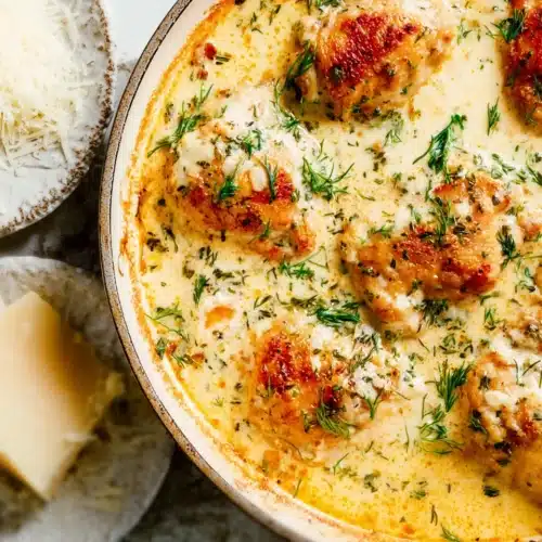 Baked Chicken Thighs (Creamy Garlic Butter Style) 6 Creamy garlic butter chicken thighs in skillet topped with fresh herbs