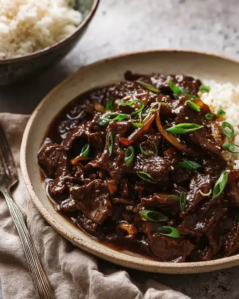 Beef stir fry with honey pepper sauce in a bowl topped with green onions