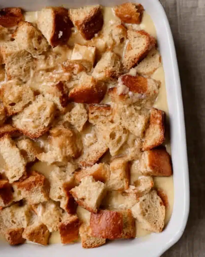 Brioche bread cubes soaked in custard in casserole dish before baking