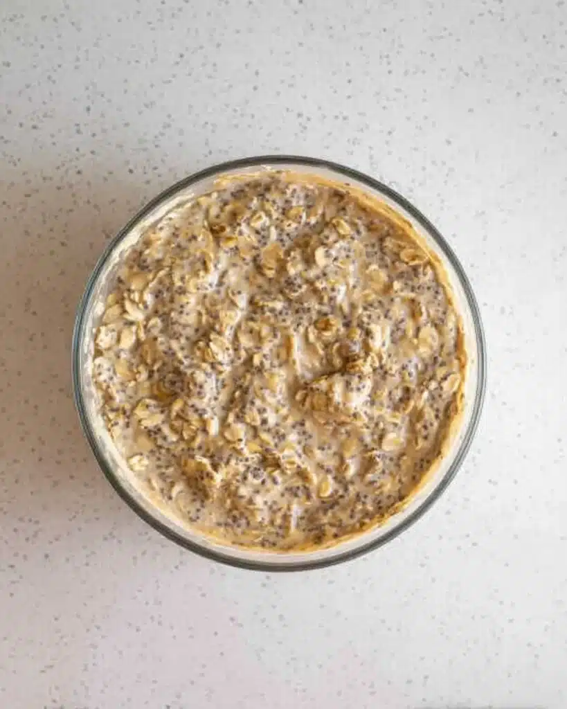 Mixed brown sugar overnight oats with banana and chia seeds in a glass bowl