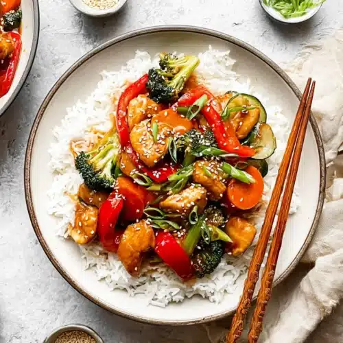Easy Chicken Stir Fry (Quick, Flavorful, and Perfect for Busy Nights) 5 Chicken stir fry with rice, vegetables, and sesame seeds on a white plate