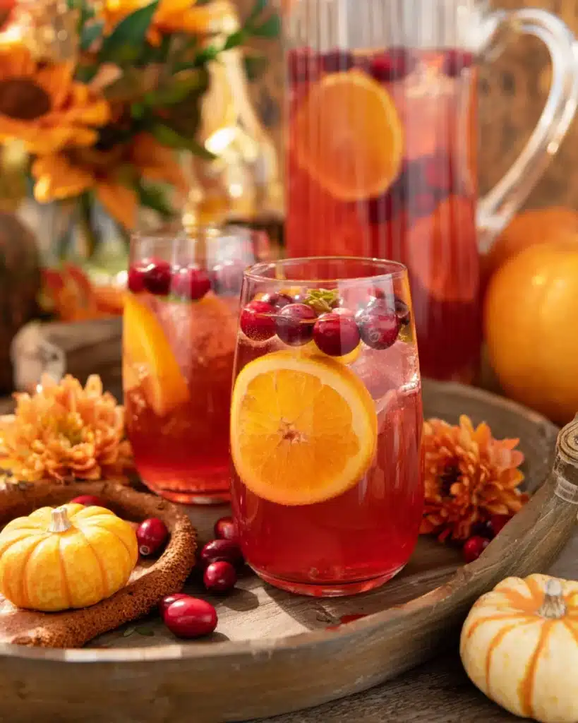 Cranberry orange prosecco punch with citrus slices and cranberries on a rustic fall table
