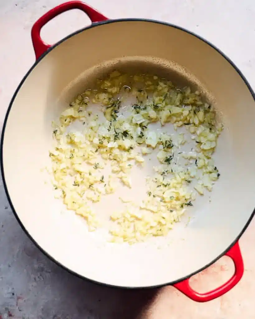 Sauteed onions and garlic for creamy leek and chicken soup in a Dutch oven