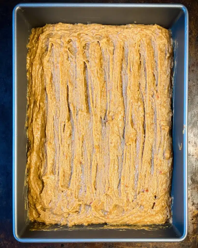 Pumpkin carrot cake batter spread in a baking pan before baking