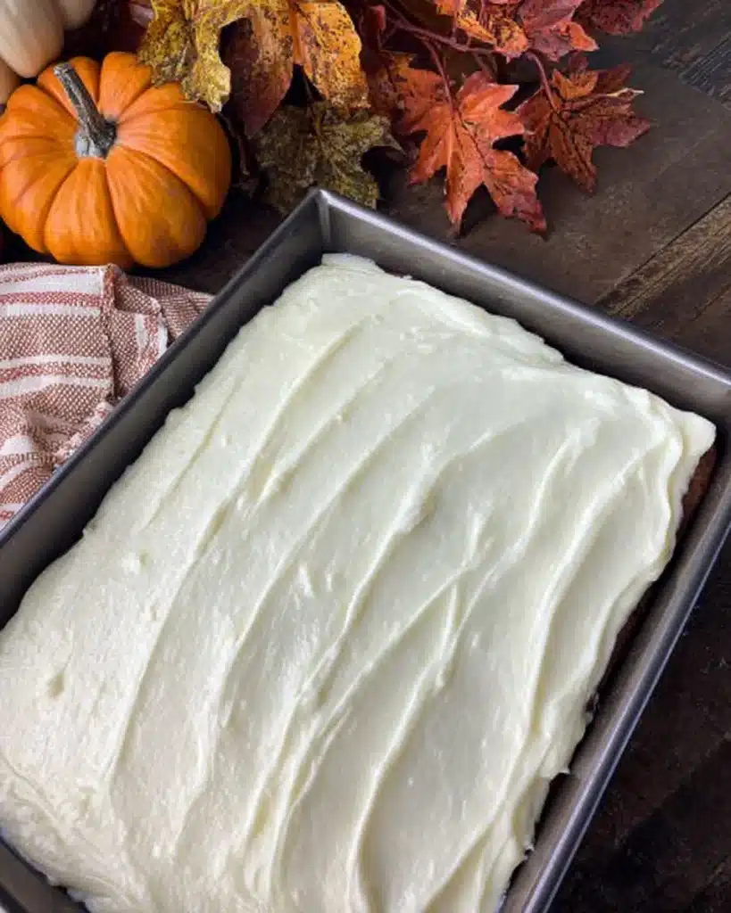 Frosted Easy Pumpkin Carrot Cake in a pan with creamy white frosting