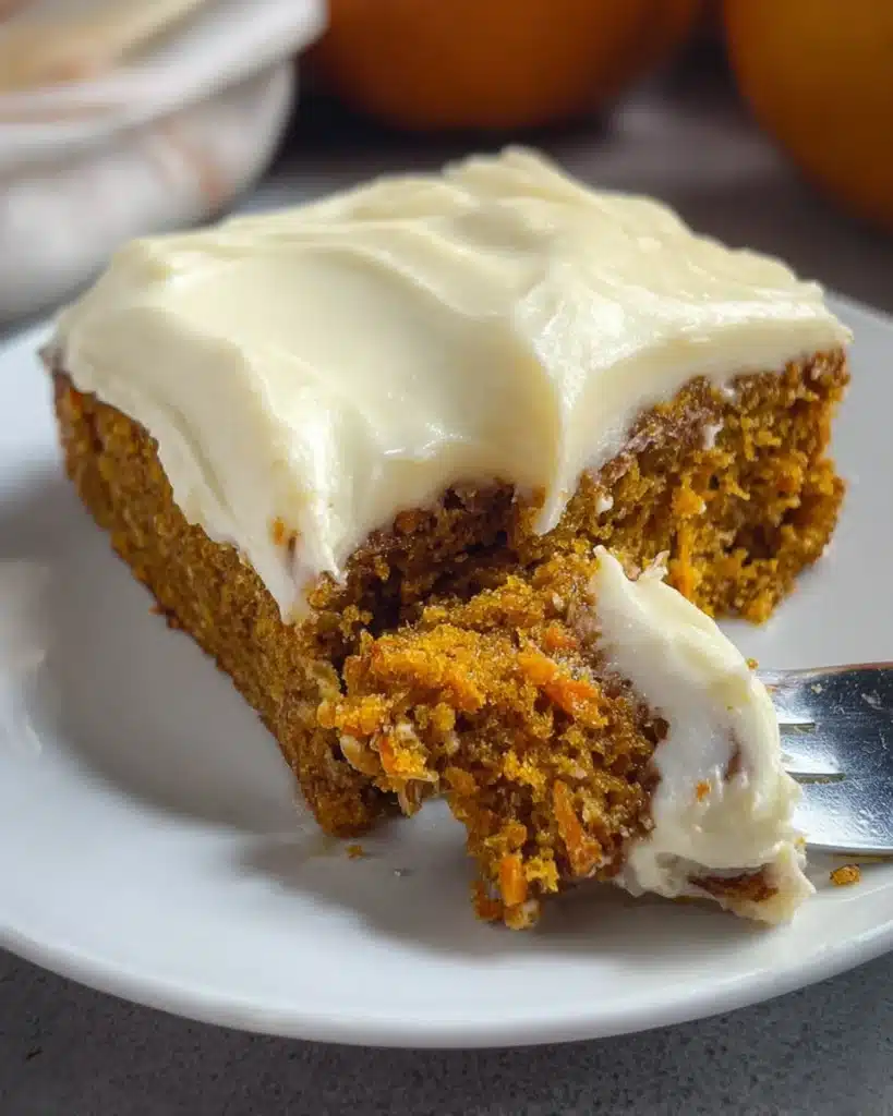Slice of Easy Pumpkin Carrot Cake with creamy frosting on a white plate