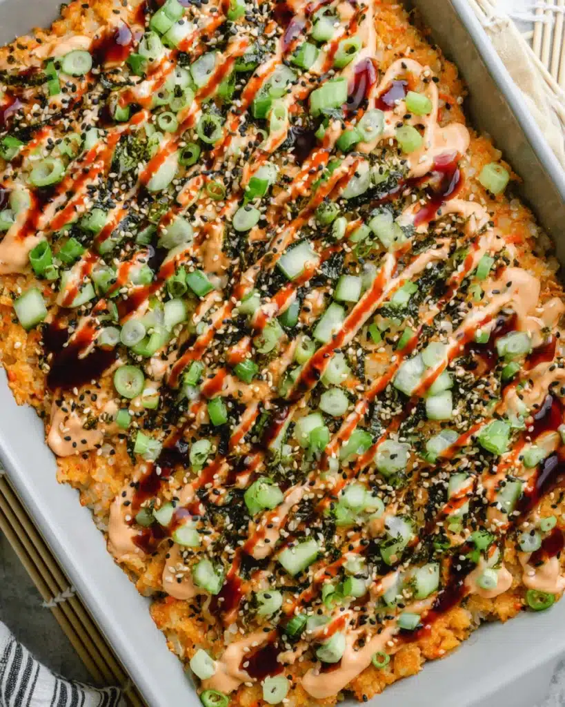 Top view of easy sushi bake with spicy mayo, cucumber, and unagi sauce drizzle