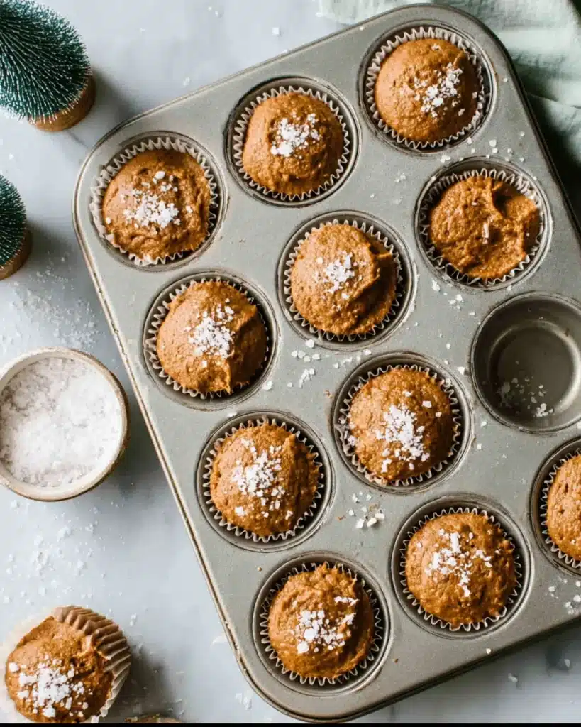 Gingerbread Muffins 3 Gingerbread muffin batter in muffin tin topped with coarse sugar