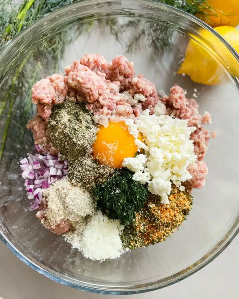 Ground turkey mixture with feta, herbs, and spices in a glass bowl