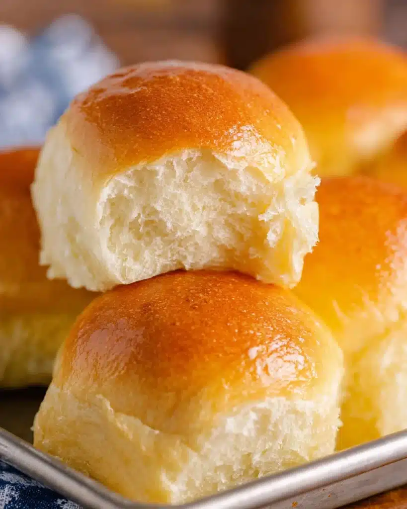 Soft homemade dinner roll torn open showing fluffy interior