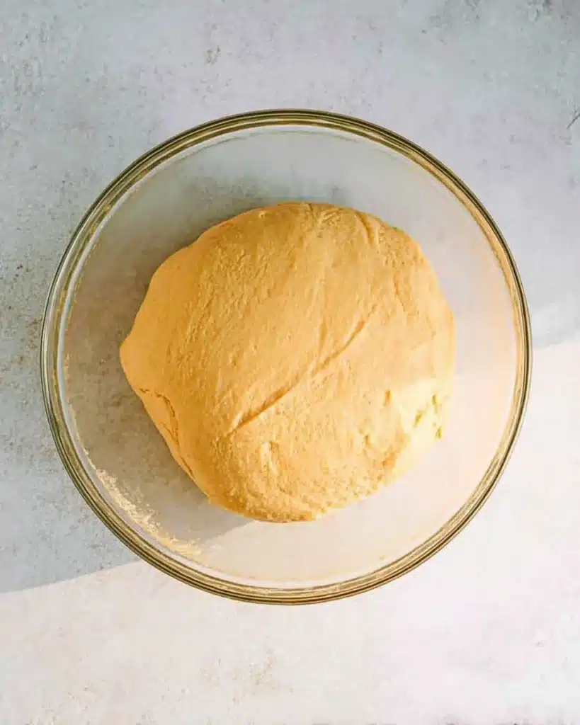 Soft homemade dinner roll dough in a bowl before rising