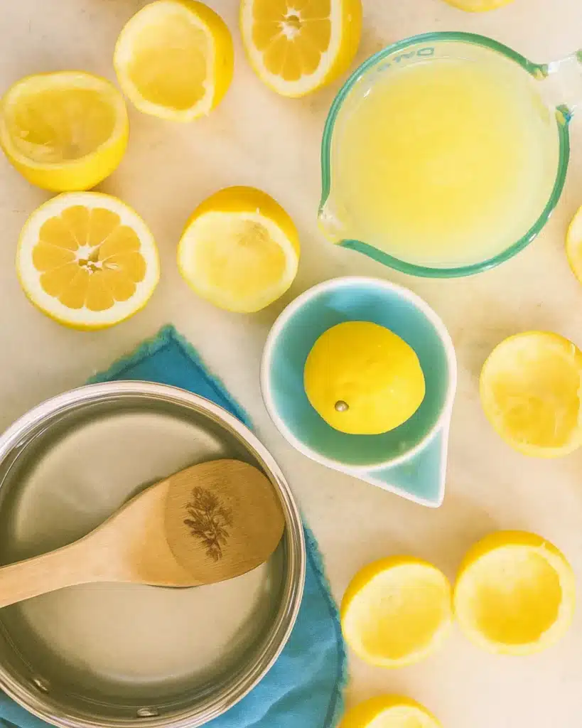Fresh lemons and ingredients for homemade lemonade on a marble surface