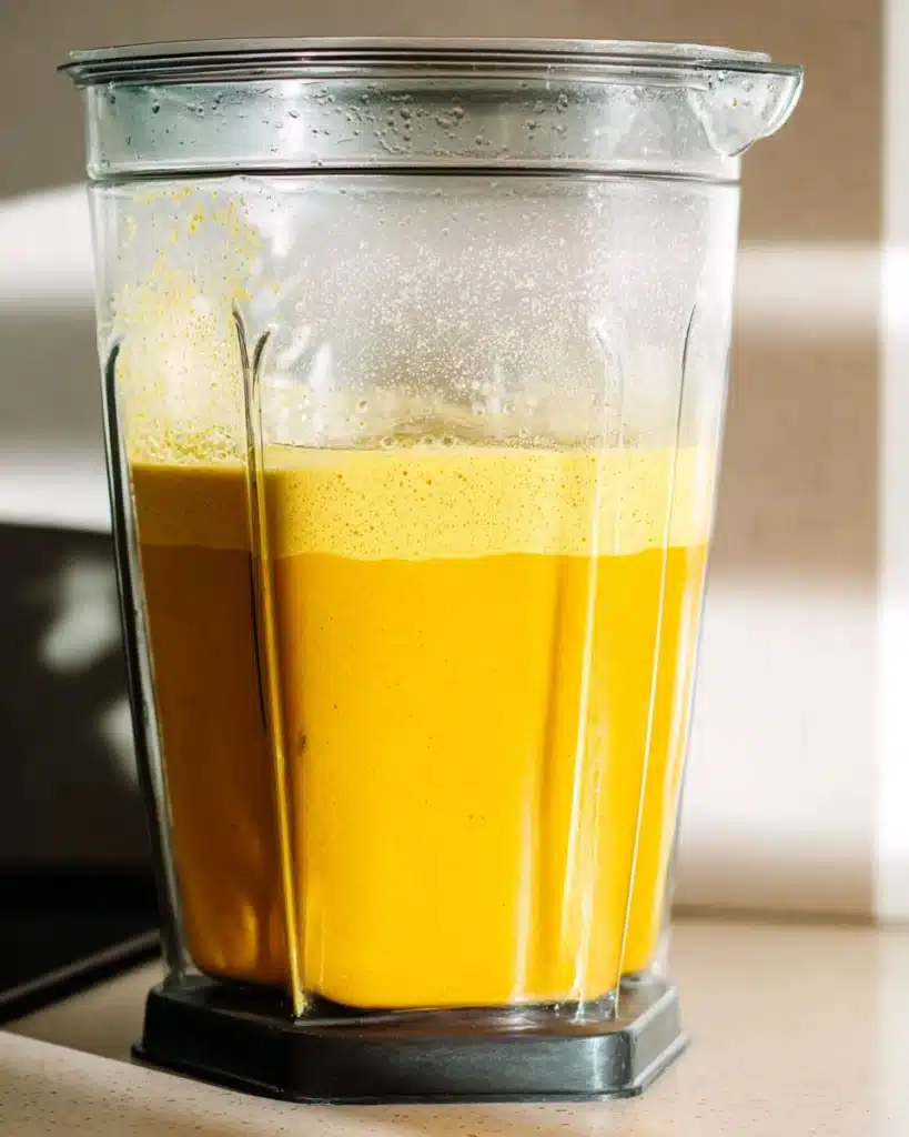 Blender filled with golden Jamu Juice made from turmeric, ginger, and lemon
