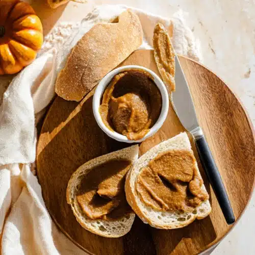 Quick and Easy Pumpkin Butter 7 Rustic bread with creamy pumpkin butter on wooden board, cozy fall breakfast