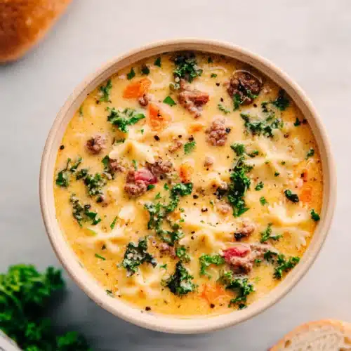 Sausage Pasta Soup (Creamy and Hearty One-Pot Meal) 7 Creamy sausage pasta soup with kale, carrots, and bowtie pasta in a beige bowl
