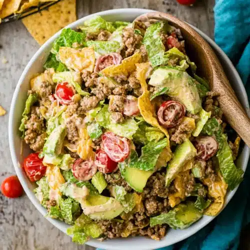 Taco Salad Recipe with avocado, tomatoes, lettuce, beef, and cheese in a white bowl