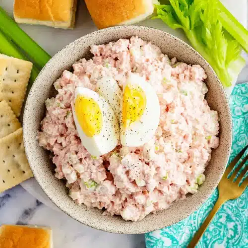 The Best Ham Salad with egg and crackers in a speckled bowl on a marble surface