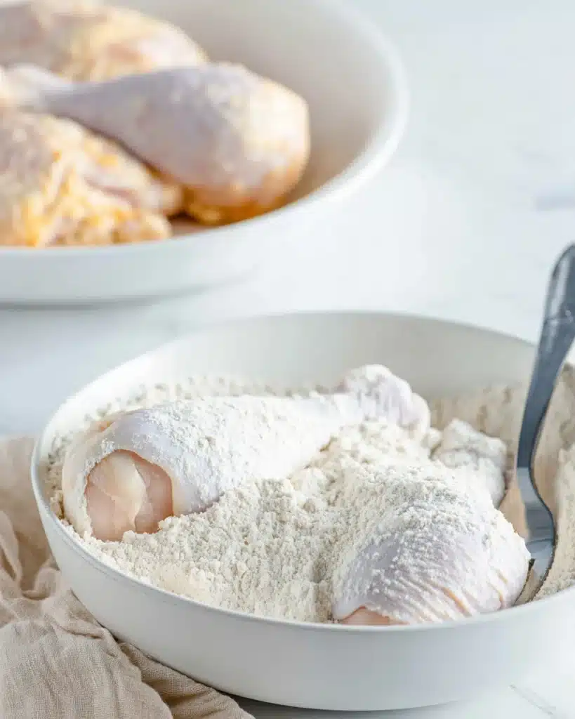 Chicken drumsticks coated in seasoned flour for Southern fried chicken