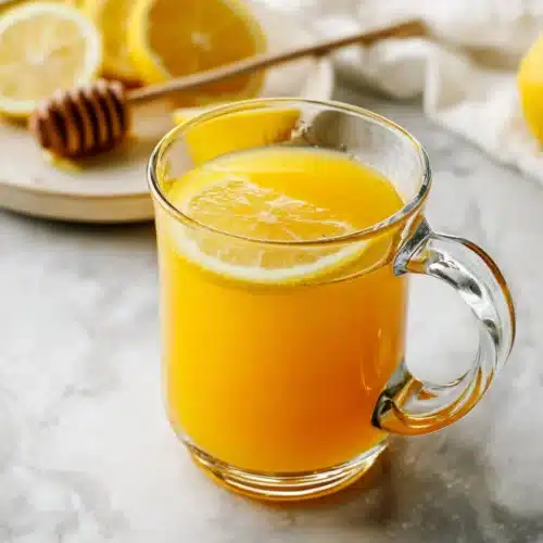 Turmeric Tea Recipe (Easy, Soothing & Detoxifying) 4 Golden turmeric tea with lemon slice and honey on marble surface