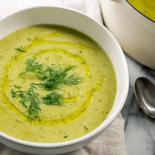 Zucchini Soup 6 Creamy zucchini soup in white bowl with olive oil drizzle and fresh dill