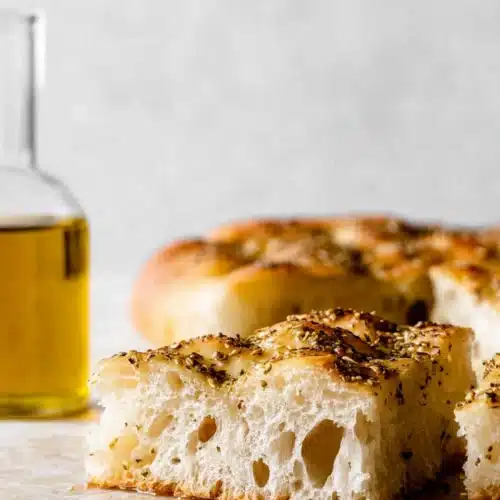 easy no-knead za'atar focaccia bread with golden crust and olive oil on a light surface