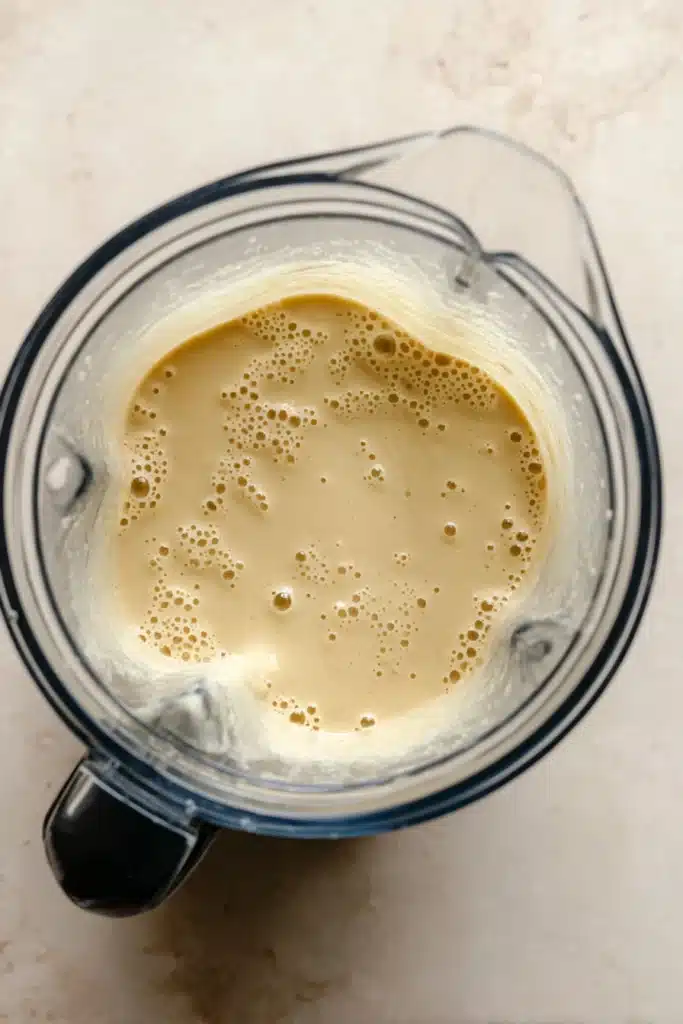 Creamy blended cheddar cauliflower soup in a blender ready to simmer