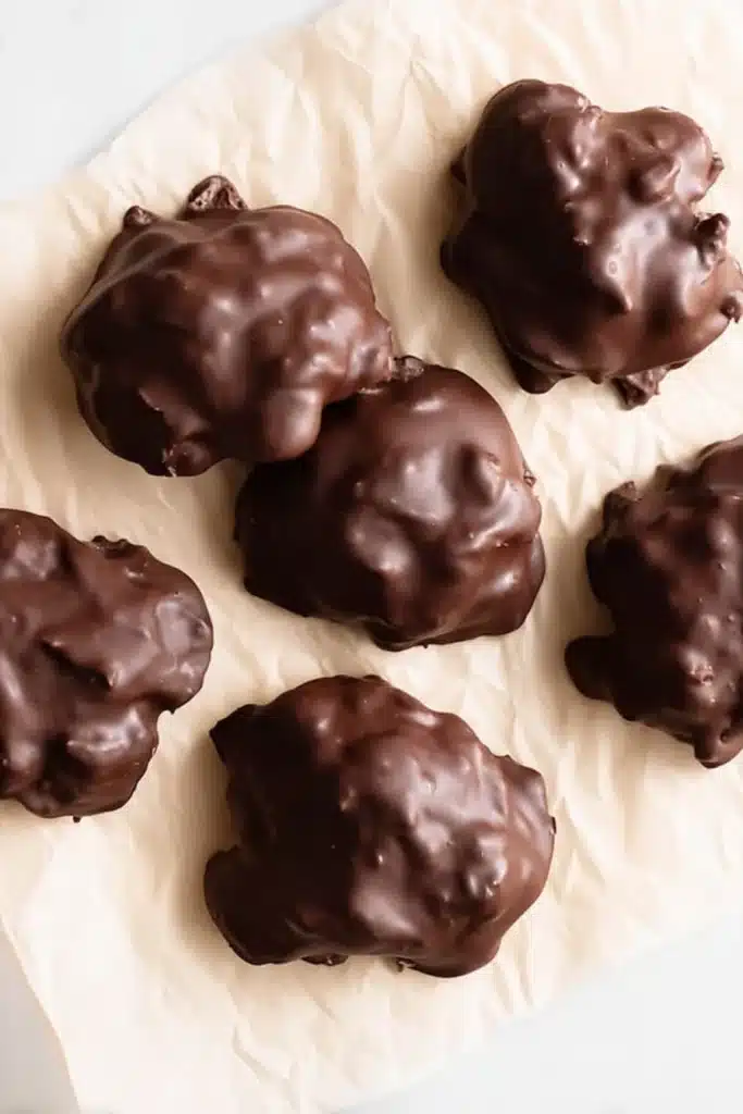Chocolate-coated strawberry yogurt clusters on parchment paper