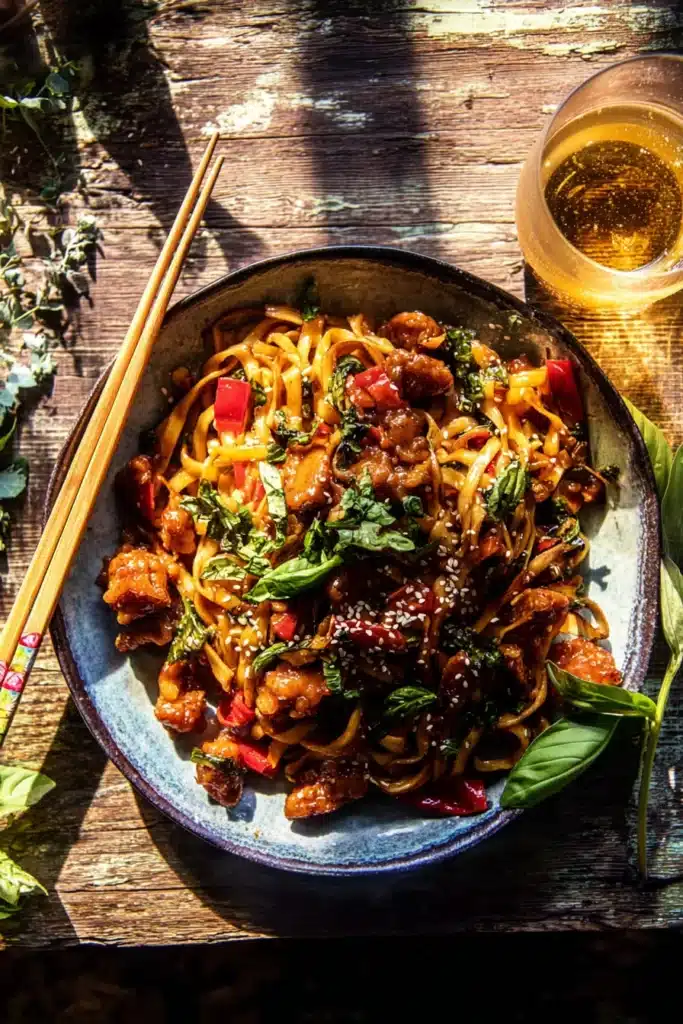 Garlic Chicken Noodles: A Fast, Flavor-Packed Dinner in 20 Minutes 1 Garlic chicken noodles with crispy chicken, basil, and sesame seeds on a rustic table