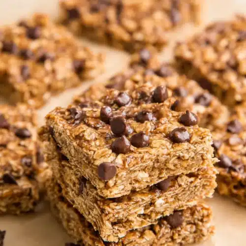 Healthy banana oatmeal bars with chocolate chips stacked on a beige surface