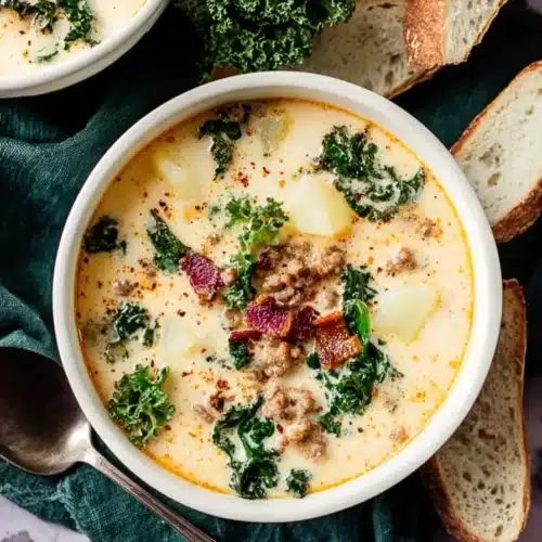 Creamy Zuppa Toscana soup with sausage, kale, and potatoes in a white bowl