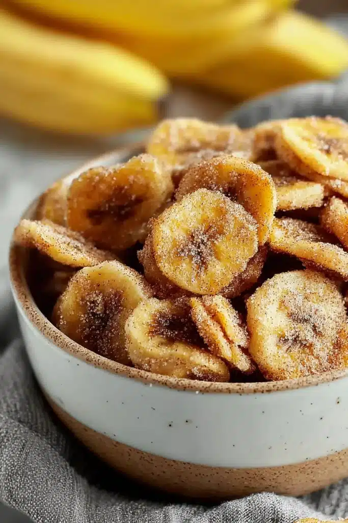 Air Fryer Cinnamon Banana Chips (Crispy, Healthy, and Ready in 15 Minutes) 2 Air fryer cinnamon banana chips coated with cinnamon sugar in a rustic bowl