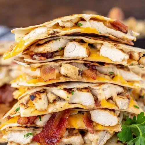 Stack of chicken bacon ranch quesadillas with melted cheese and crispy bacon