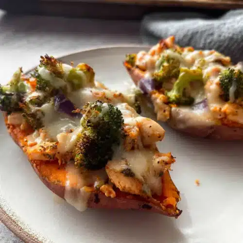 Close-up of chicken and broccoli stuffed sweet potatoes with melted cheese on a plate