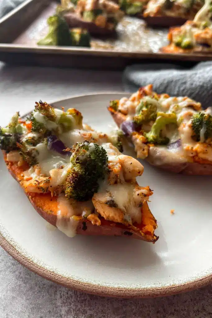 Close-up of chicken and broccoli stuffed sweet potatoes with melted cheese on a plate
