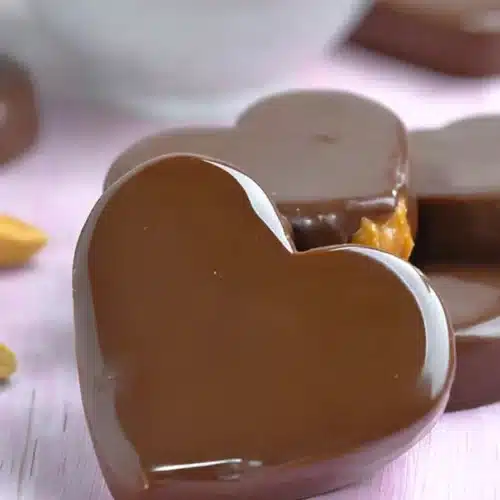 Chocolate Peanut Butter Valentine’s Heart candies on pink surface