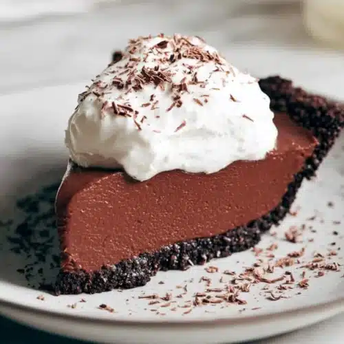 Slice of chocolate pie with whipped cream on a plate