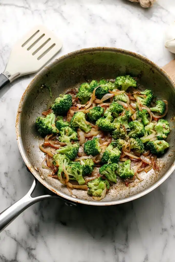 Sautéed broccoli and onions in skillet for crustless quiche